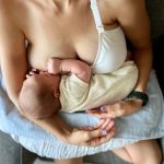A mother breastfeeding her newborn while holding them close, demonstrating the bond and benefits of breastfeeding. This image highlights the combination of breastfeeding and breast pumping as options for nourishing a baby.