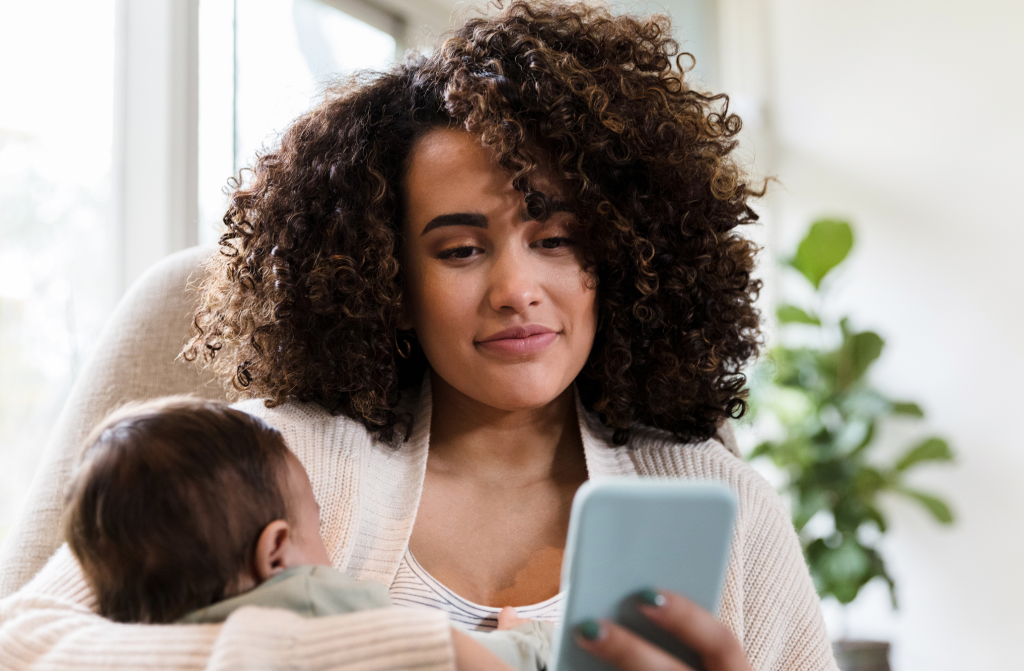 New mom uses smarphone at home comfortably while experiencing pain-free pumping