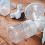 image of different breast pump parts on a brown wooden table
